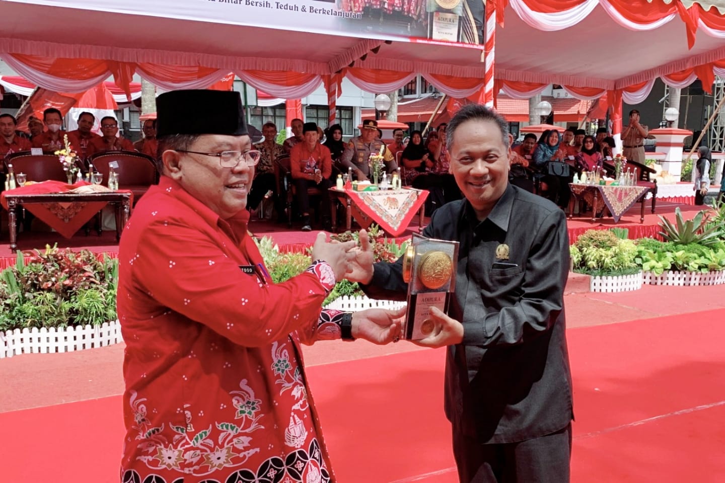TERUS PERTAHANKAN: Wali kota Santoso menyerahkan piala Adipura kepada ketua DPRD Kota Blitar Syahrul Alim