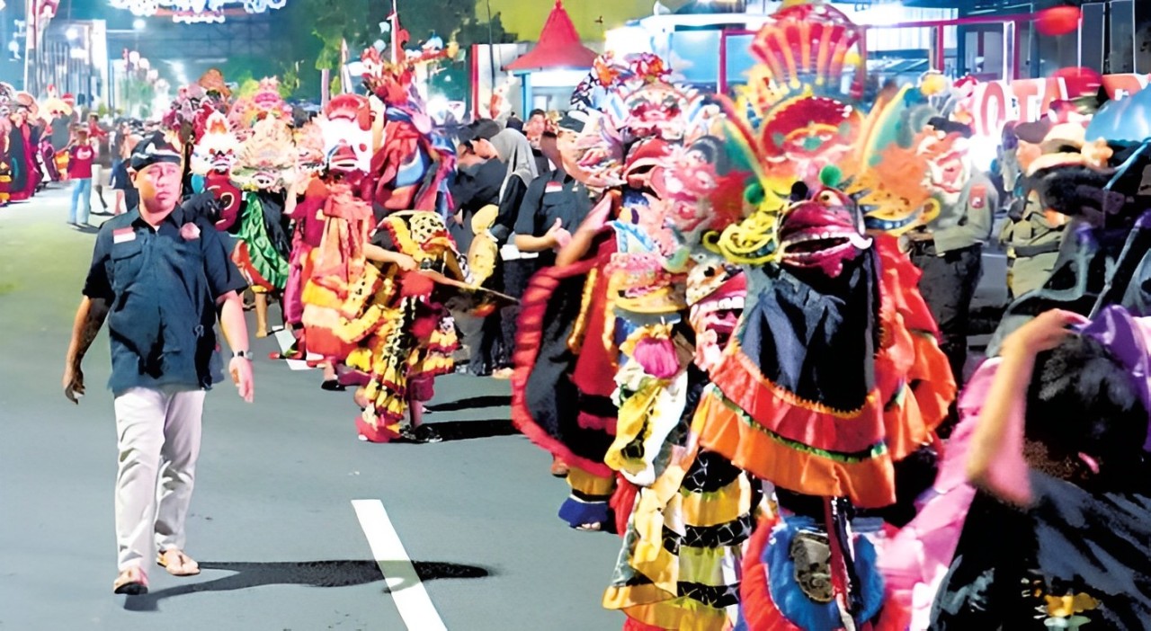 SEMARAK: Para peserta kirab barongan dengan gembira beratraksi di depan ratusan warga di Jalan A. Yani, Kota Blitar.