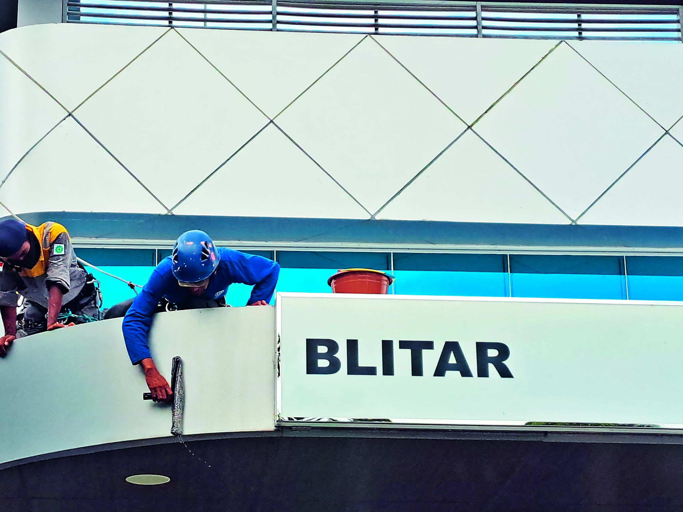 FINISHING: Seorang pekerja sedang melakukan perbaikan salah satu gedung di Kota Blitar.