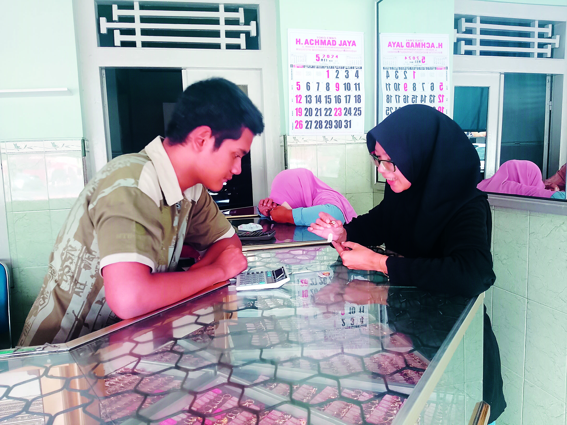 TRANSAKSI: Seorang pengunjung konsultasi untuk mengetahui harga emas yang dimilikinya.