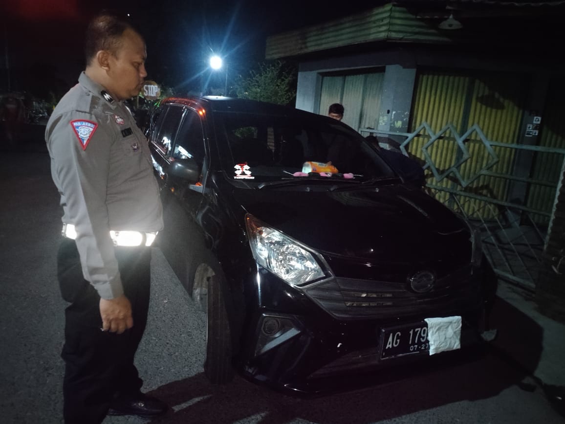 Polisi menunjukkan mobil yang ringsek akibat tersambar kereta api