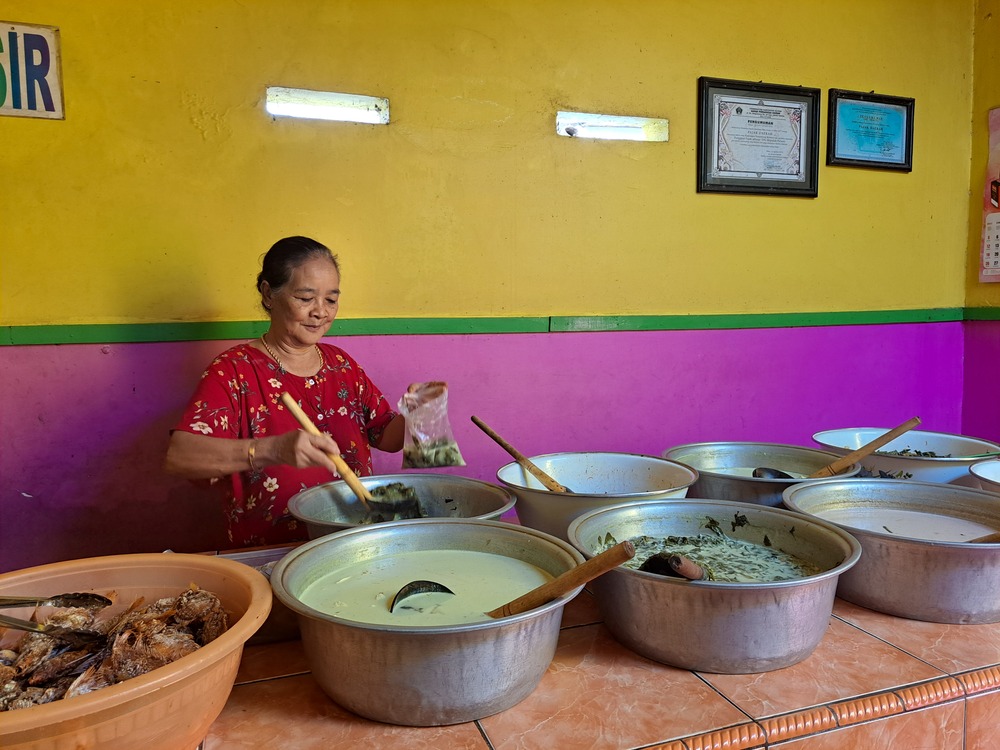 TRADISIONAL: Supiati atau akrab disapa Mak Ti mengambil sayur lodeh untuk pelanggan yang membungkus pesanan di warungnya, kemarin (26/5).