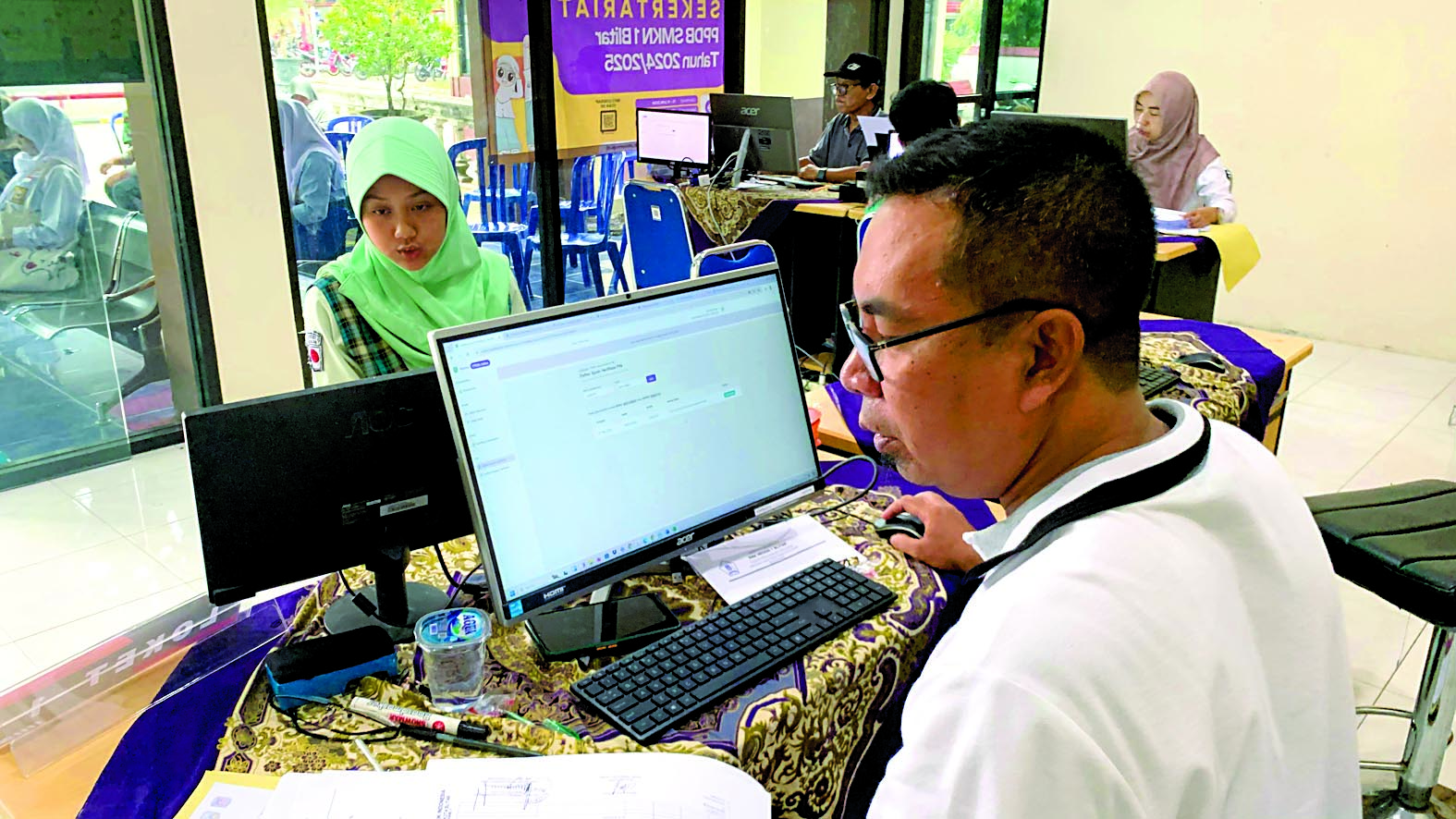 SETOR BERKAS: Calon peserta didik baru menyerahkan berkas kepada operator untuk verifikasi PIN di SMKN 1 Blitar, Rabu (29/5).