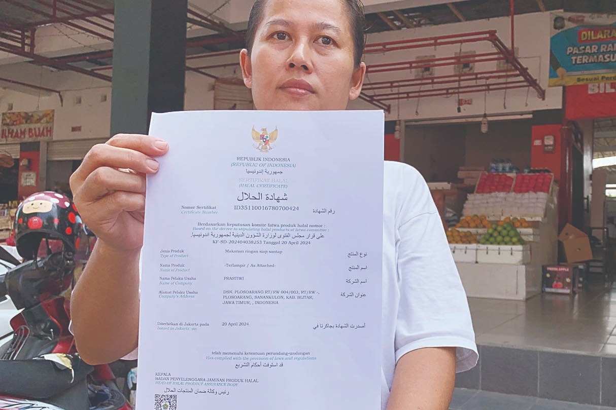 SUDAH TENANG: Prastiwi, pemilik warung makan menunjukkan sertifikat halal yang sudah diperoleh secara gratis, Rabu (29/5) lalu.
