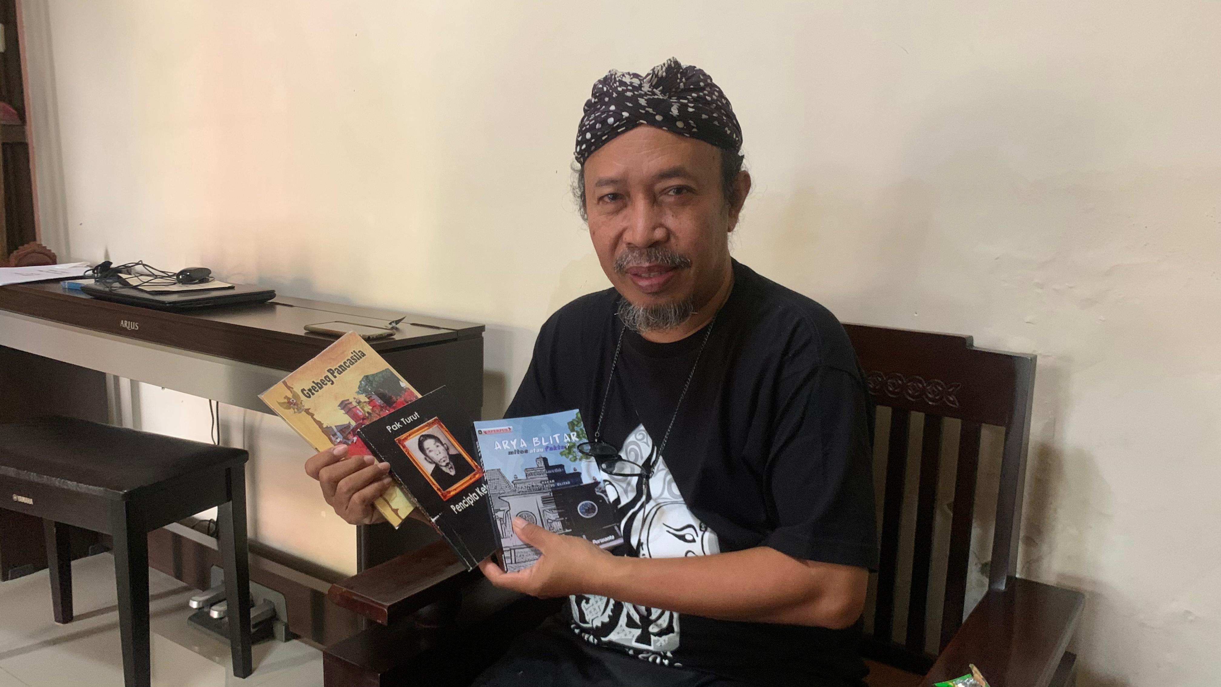 TEKUN: Purwanto, penulis buku Arya Blitar, Mitos atau Fakta, menunjukkan hasil karya buku lainnya.