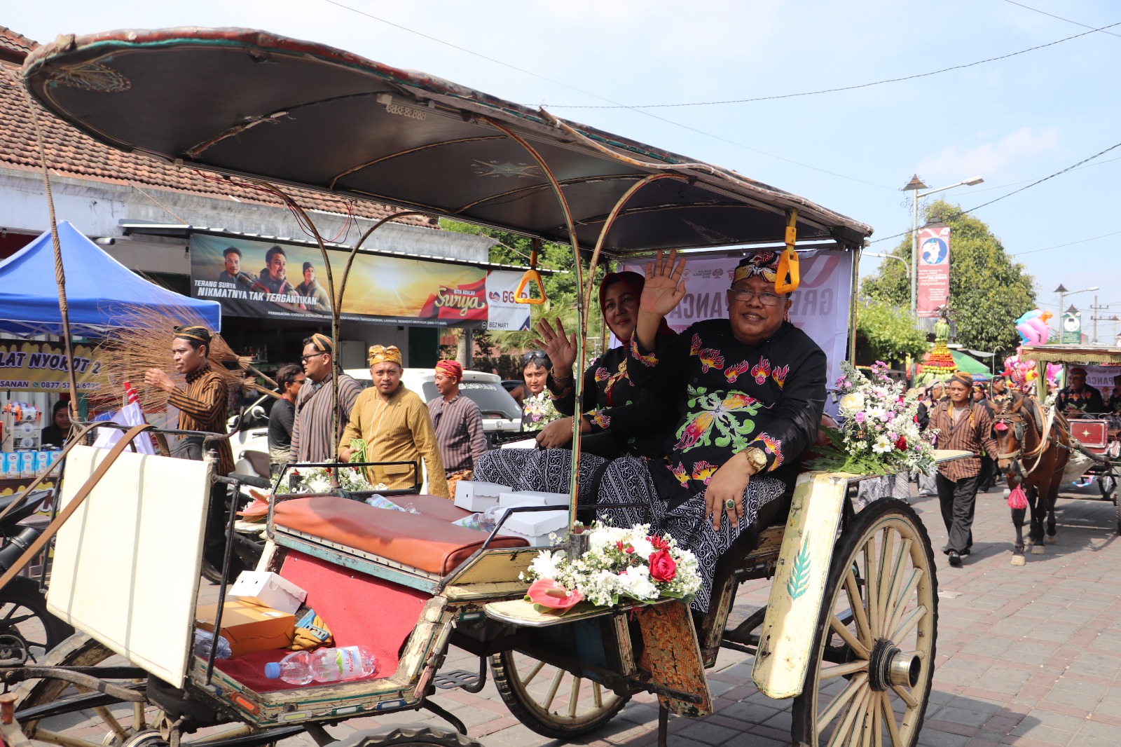 RAMAH: Wali Kota Blitar Santoso menyapa masyarakat di sepanjang jalan menuju MBK saat kirab Gunungan Lima, Sabtu (1/6/2024).