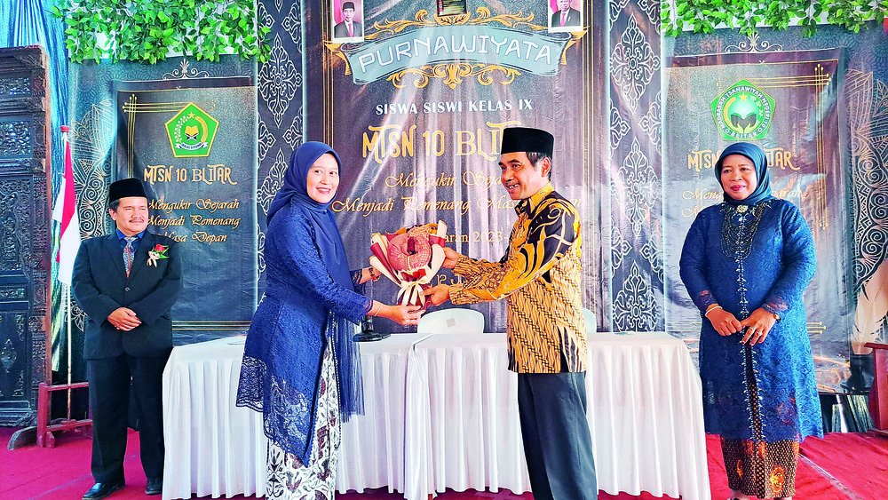 SUKSES: Agenda purnawiyata MTsN 10 Blitar berlangsung meriah pada Rabu (12/6). Kepala Kemenag Kabupaten Blitar Drs Baharuddin MPd (kanan) menerima buket dari Kepala