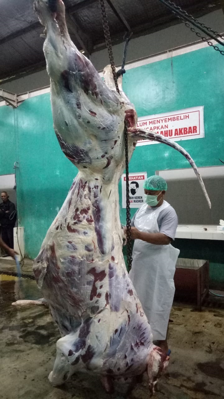 RAPI: Petugas di RPH Srengat sedang memotong-motong daging milik pelanggan.