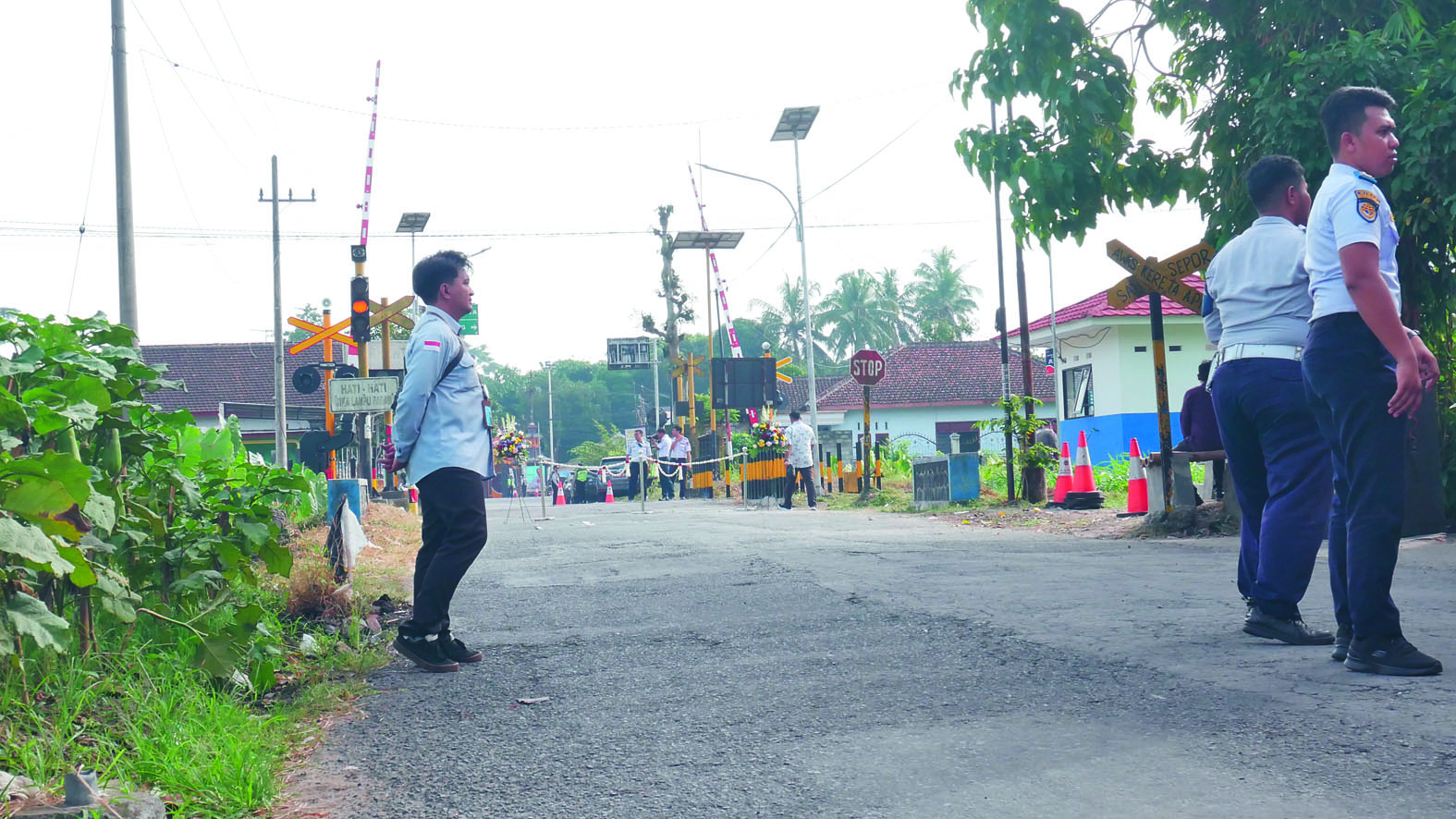 PANTAU: Petugas Dishub Kabupaten Blitar berdiri di depan perlintasan di Kelurahan Bence, Kecamatan Garum.