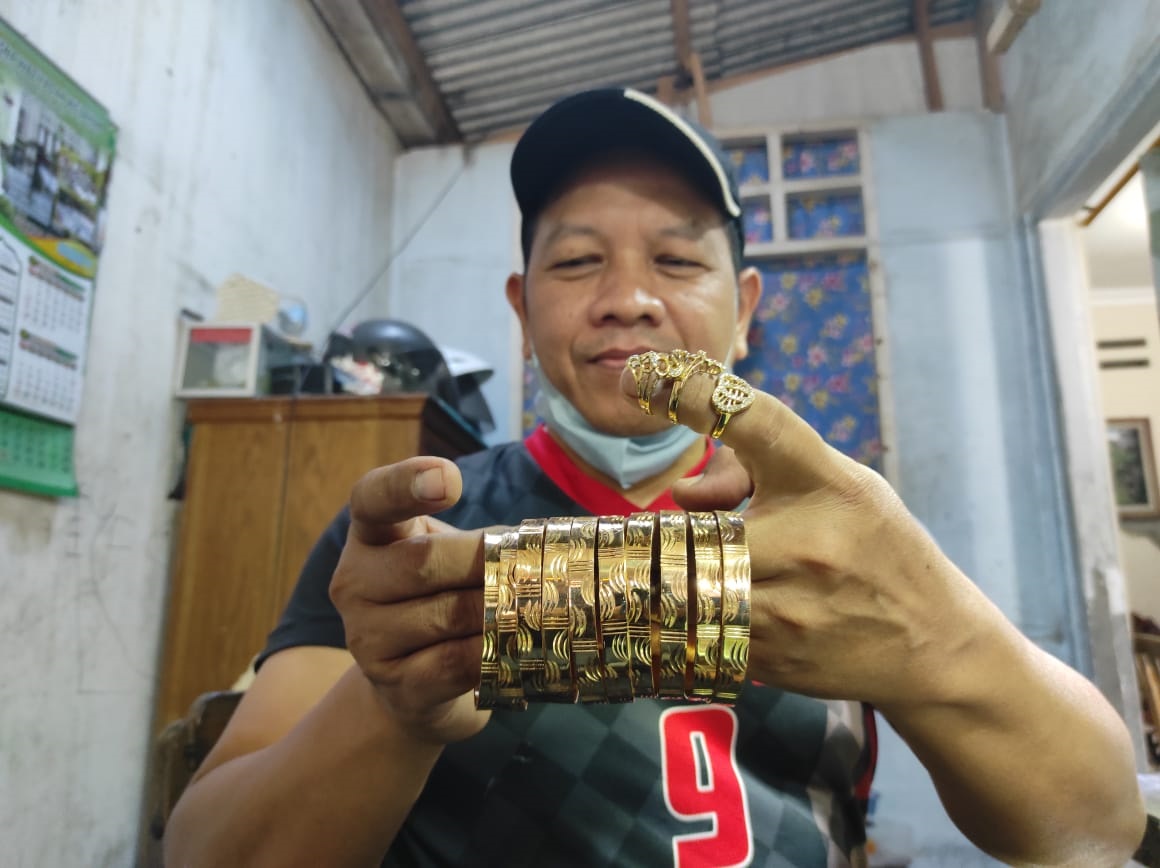 BERGAYA : Pitoyo memperlihatkan perhiasan mamas karyanya yang terbuat dari tembaga dan kuningan.