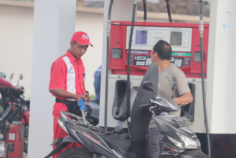 TINGKATKAN LAYANAN: Petugas SPBU memberikan layanan pada pelanggan, kemarin (22/7)