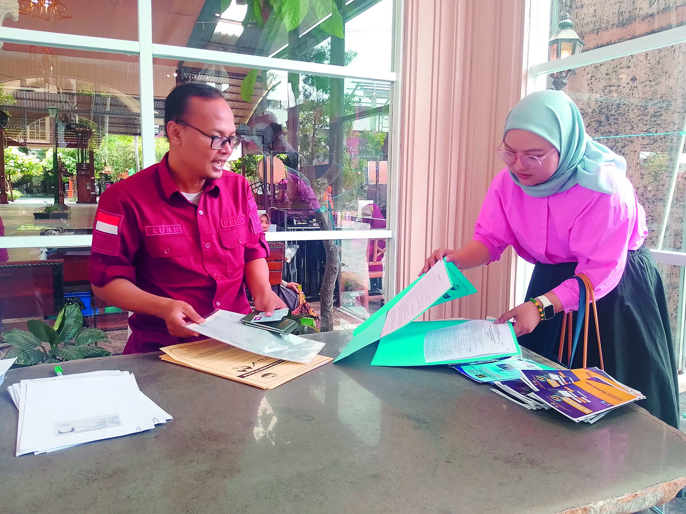 FOKUS: Warga sedang mengisi data dalam pengurusan paspor saat berada di wisata Kampung Coklat.
