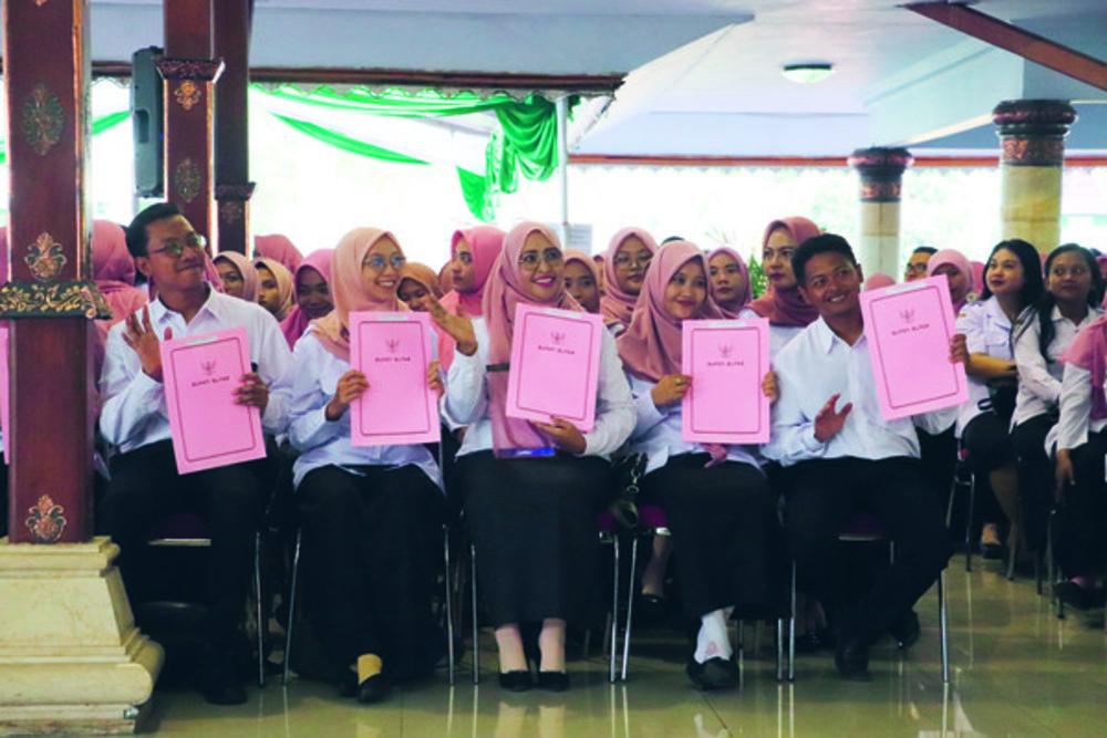 DISIPLIN: Sejumlah PPPK menunjukkan map merah berisi ikatan kontrak kerja dengan pemerintah.