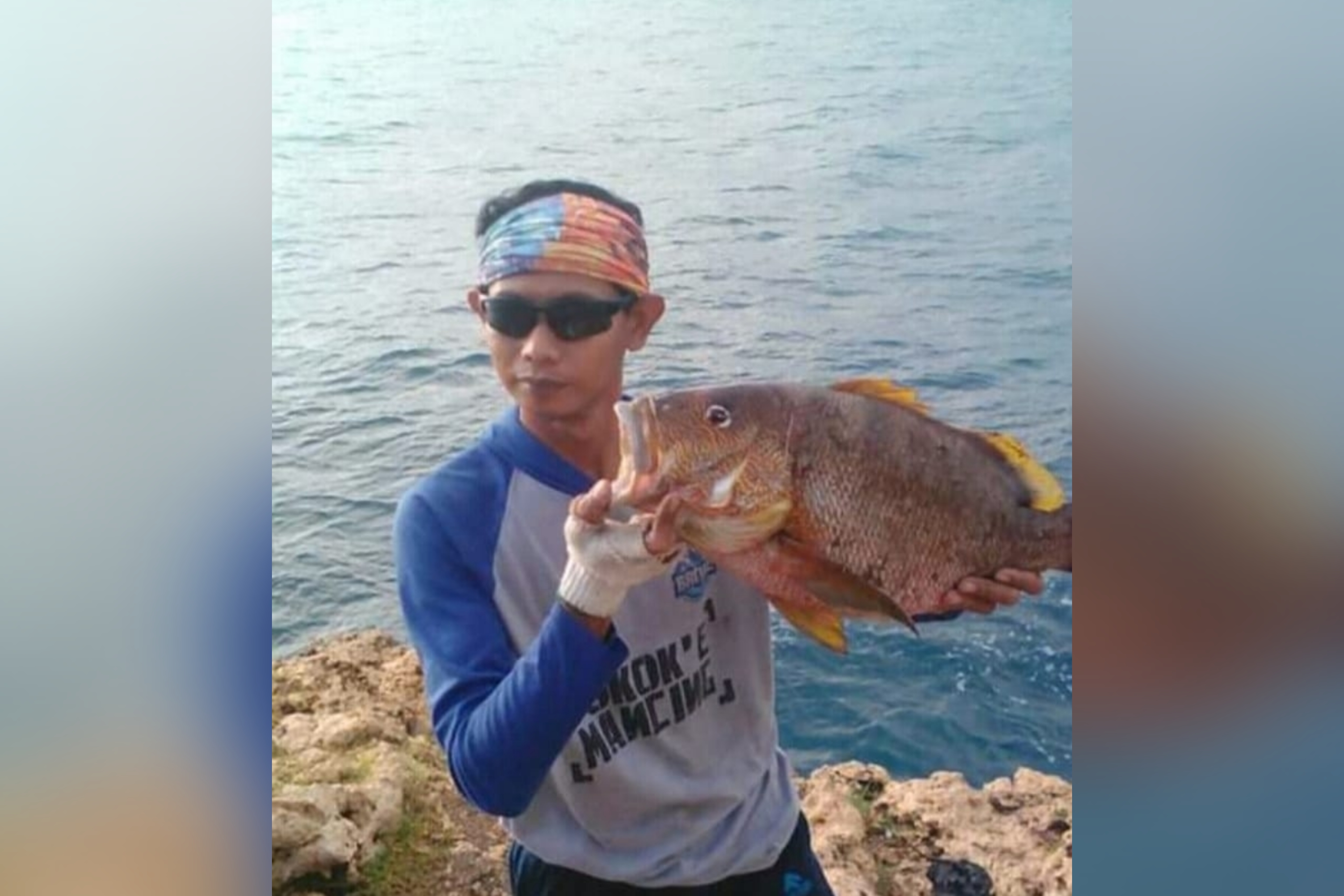 STRIKE: Kades Ngeni, Iwan Haris Efendi, saat memamerkan ikan hasil pancingan di laut.