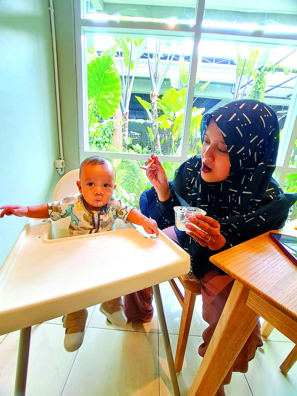 CEGAH OBESITAS: Nisa Nur menyuapi bayinya, Abimana, dengan makanan pendamping ASI. Sejak lahir, Nisa berupaya memberikan ASI eksklusif.