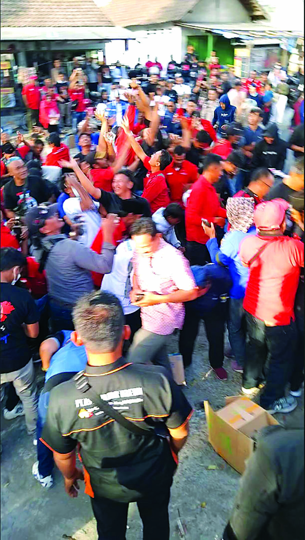 HUJAN DUIT: Puluhan relawan Rizky berebut uang yang disebar di  depan kantor KPU Kabupaten Blitar, Selasa (27/8).