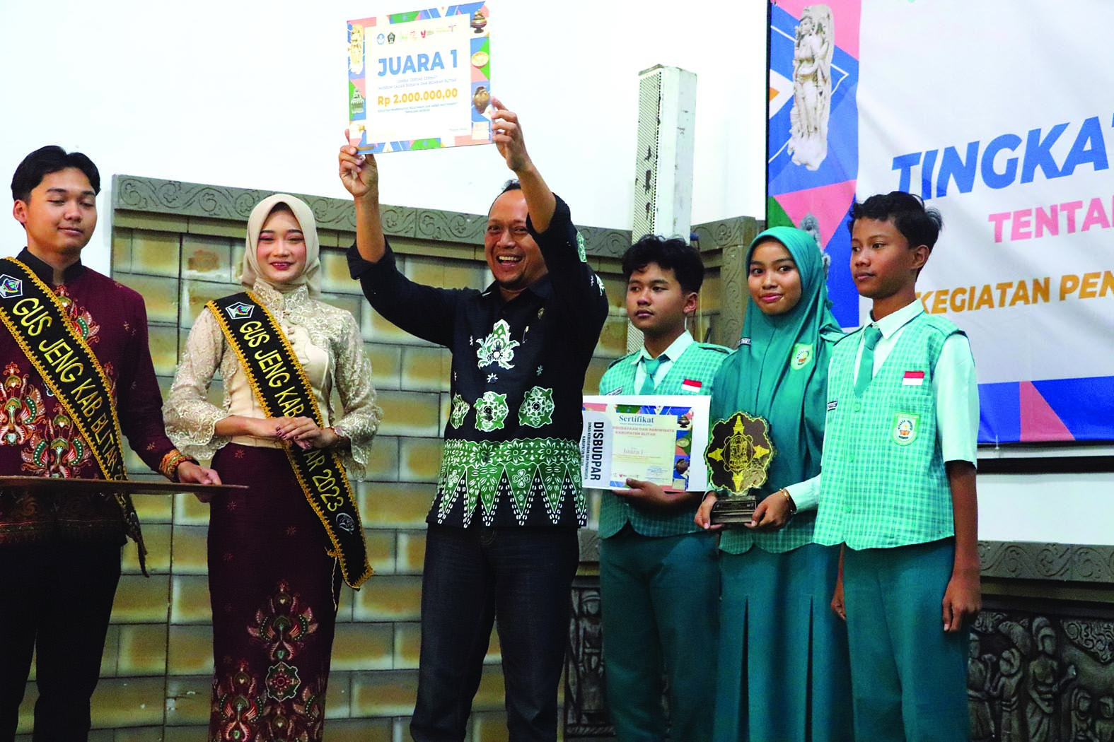 SUKSES: Kabid Kebudayaan Ainu Rofiq memberikan hadiah dan penghargaan  kepada juara 1 lomba cerdas cermat diraih SMPN 1 Kesamben.