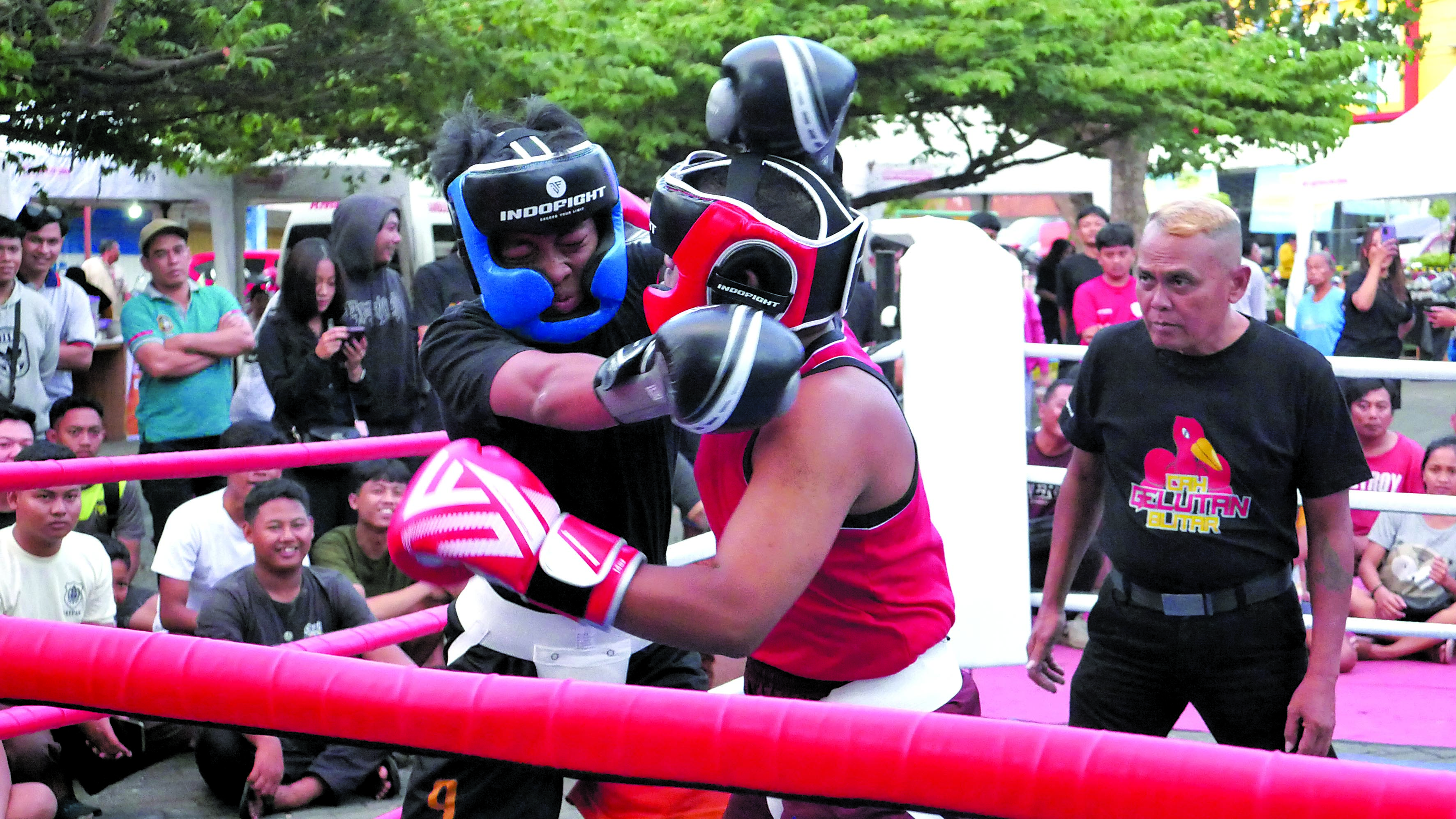 SERU-SERUAN: Peserta tinju amatir duel di atas ring yang digelar di halaman Pasar Legi, Jumat (6/9) lalu. Pertunjukan olahraga tersebut menyedot antusiasme masyarakat.