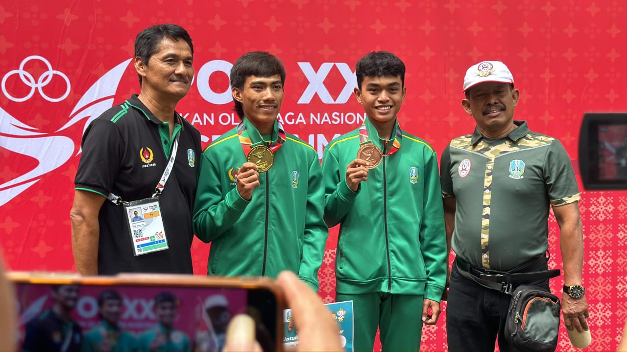 BERKAT: Adrian Kurniawan menunjukkan medali emas usai menjuara MTB XCR dalam ajang PON XXI.