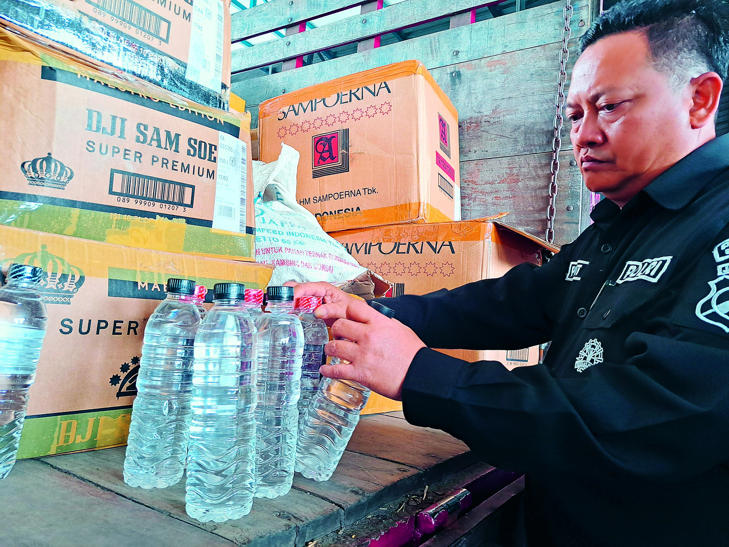 TERLARANG : Polisi menunjukkan barang bukti miras jenis arak bali yang diangkut menggunakan truk merah, kemarin (10/9).