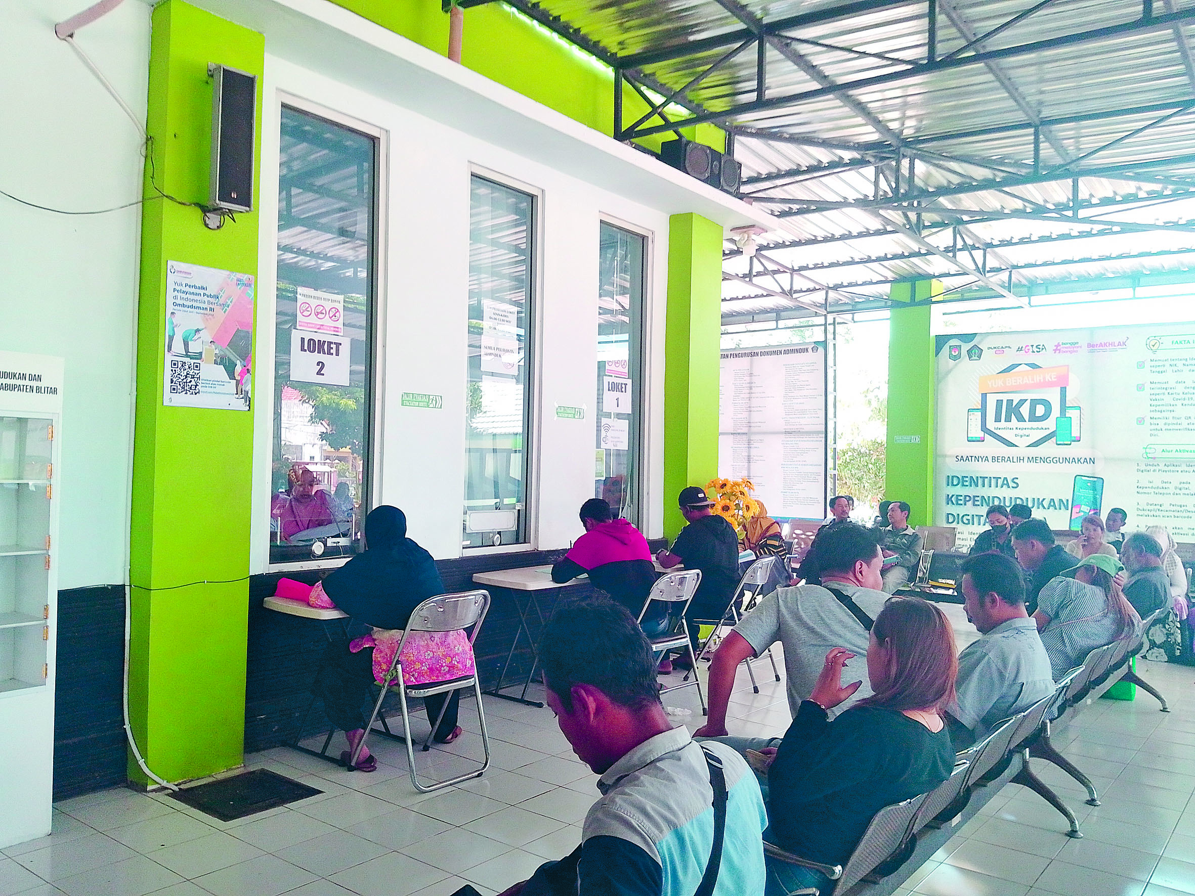 KOMUNIKATIF: Pegawai dispendukcapil sedang melayani masyarakat yang mengurus data kependudukan.