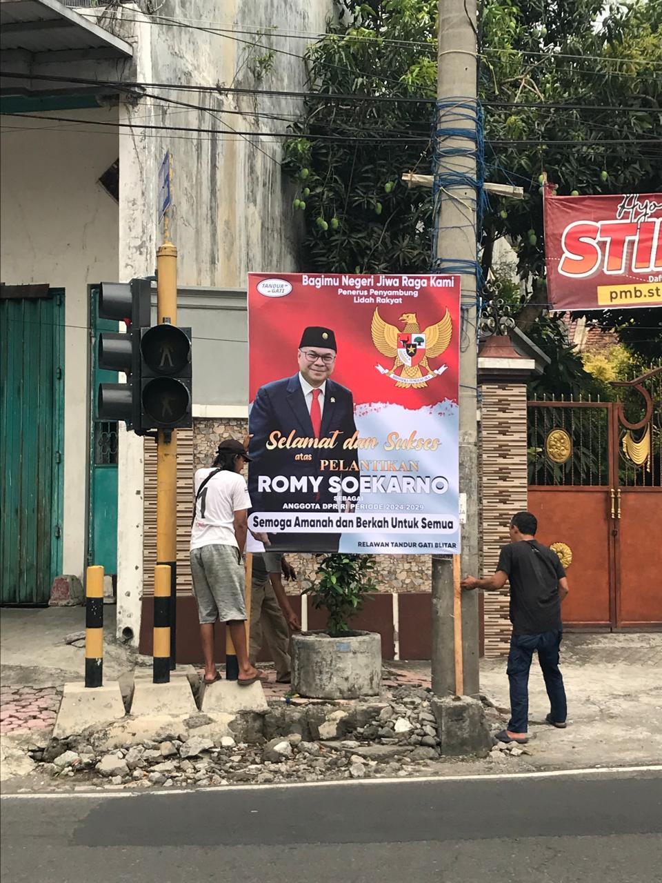 Anggota Relawan Tandur Gati Blitar memasang reklame ucapan selamat untuk Romy Soekarno