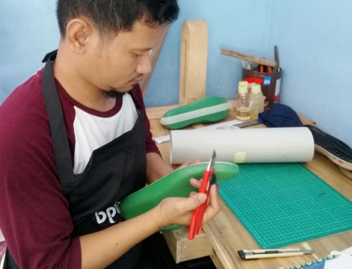 CEKATAN: Saiful Anwar saat berkarya di Galeri Omah Kulit Soeya, untuk menghasilkan sandal kulit berkualitas.