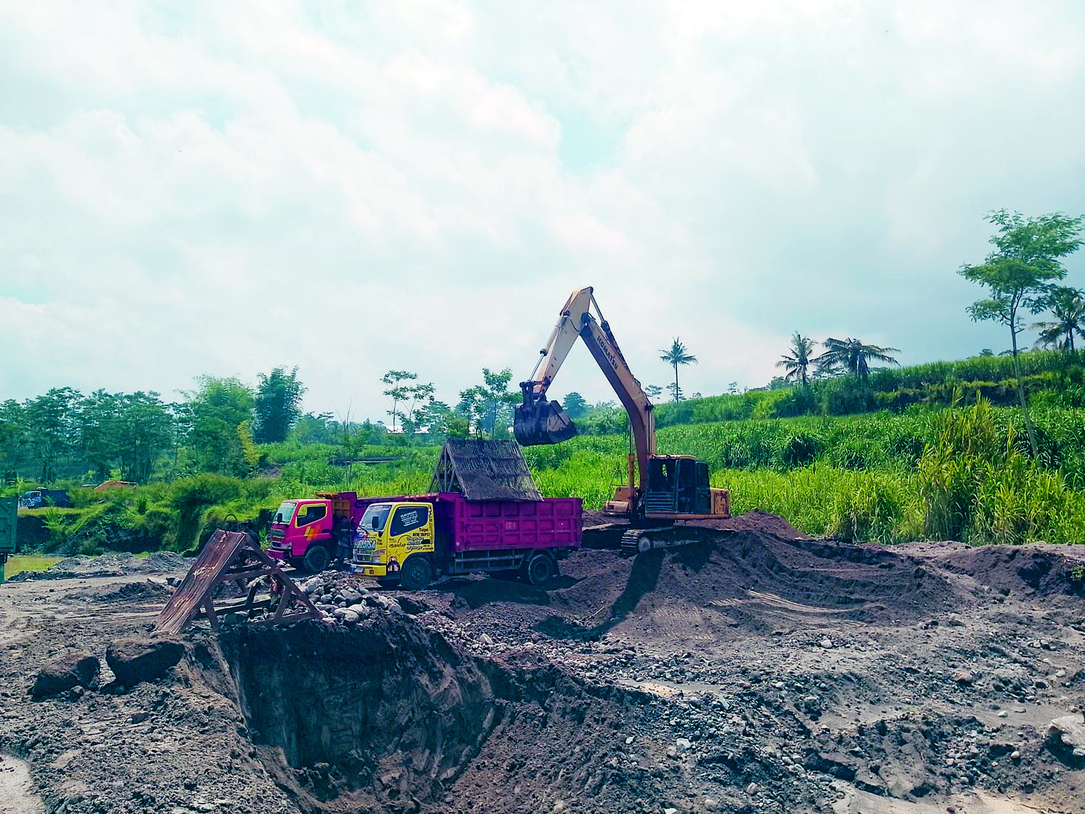 PENUH: Alat berat memindahkan material tambang pasir dan batu ke truk.