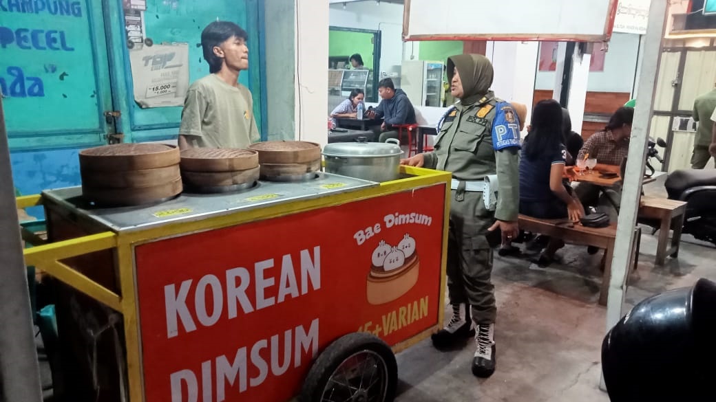 DEMI KETERTIBAN: Petugas Satpol PP sosialisasi tentang aturan berjualan di trotoar sekaligus memperingatkan PKL yang bandel.