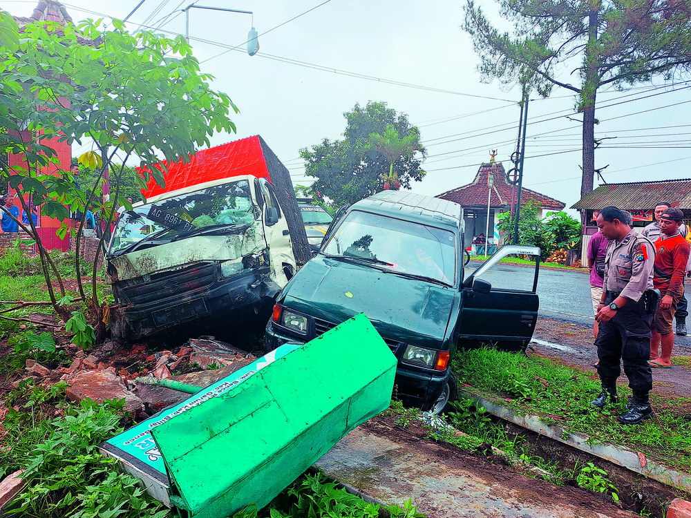 NAHAS: Warga mengevakuasi mobil pikap dan Panther yang kecelakaan di jalan raya Kelurahan Bence, Kecamatan Garum, Rabu (23/10)