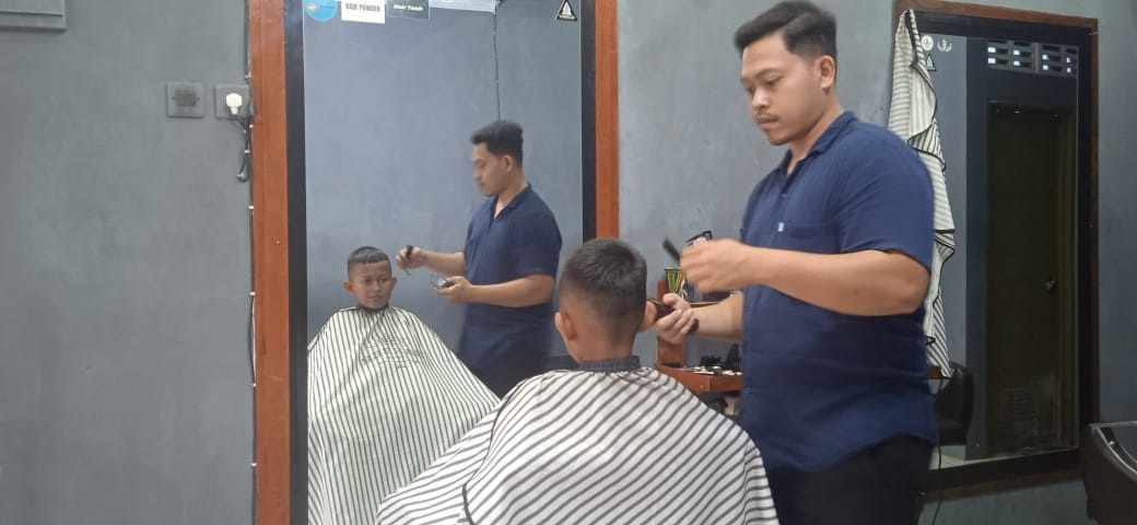 FOKUS: Salah  satu barber  man sedang  mencukur  pelanggan  anak-anak