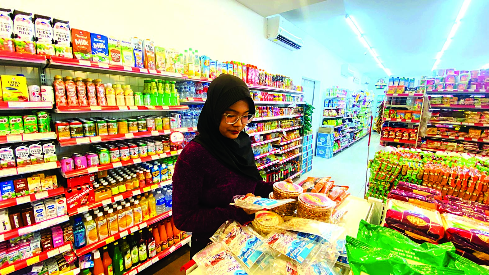 MASIH MARAK: Seorang warga berbelanja di salah satu toko modern yang telah berizin resmi beberapa waktu lalu.