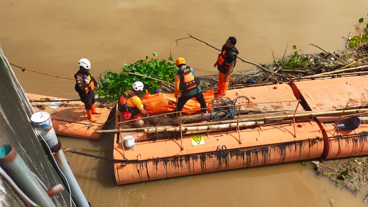 MEMBUSUK : Petugas gabungan melakukan evakuasi jenazah Wawan Efendi yang terapung di Sungai Brantas