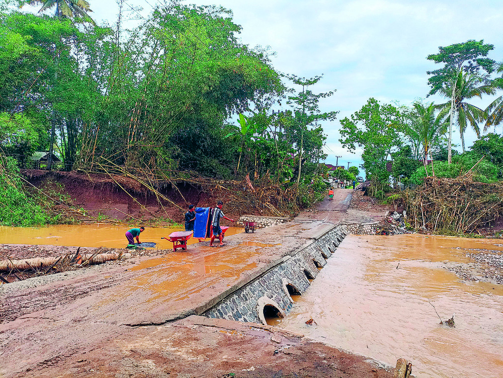 KOTOR: Warga sedang membersihkan sabo dam yang licin karena lumpur saat banjir bandang melanda Desa Sambigede, Kecamatan Binangun. Kelangkaan air bersih menjadi persoalan baru bagi warga terdampak ban