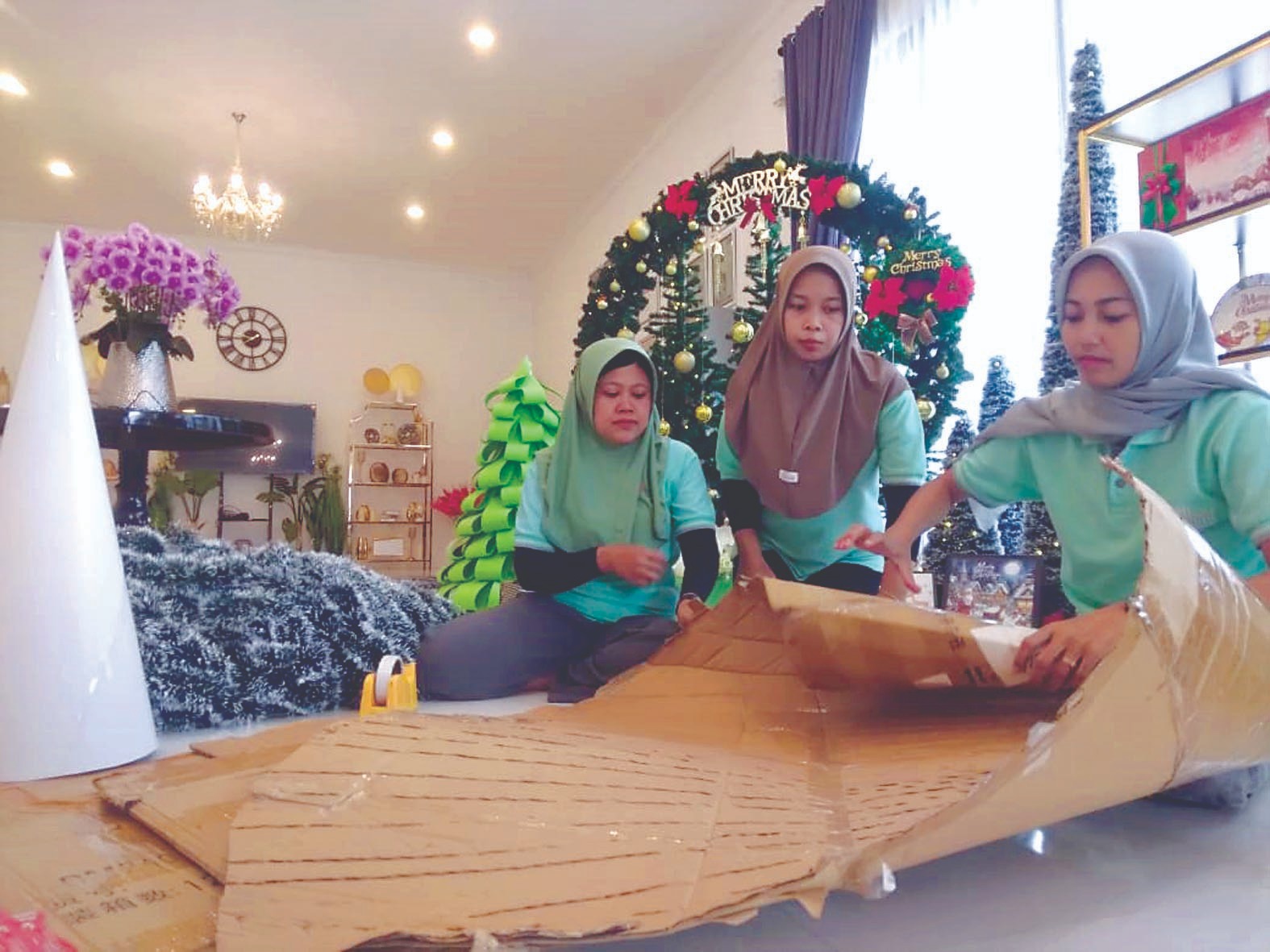 KREATIF: Sejumlah pekerja menyelesaikan pesanan pohon Natal dari kardus bekas karya Andris Prasetyo, kemarin (12/12).