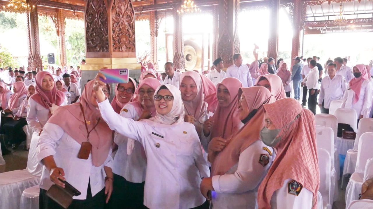 MENGHILANG: Bupati Rini Syarifah melayani permintaan foto bersama para guru usai kegiatan. Saat ini bupati jarang terlihat di muka publik.