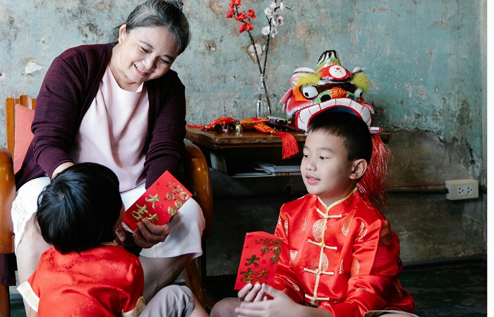 Seorang nenek yang membagikan angpao kepda cucu-cucunya saat perayaan Imlek