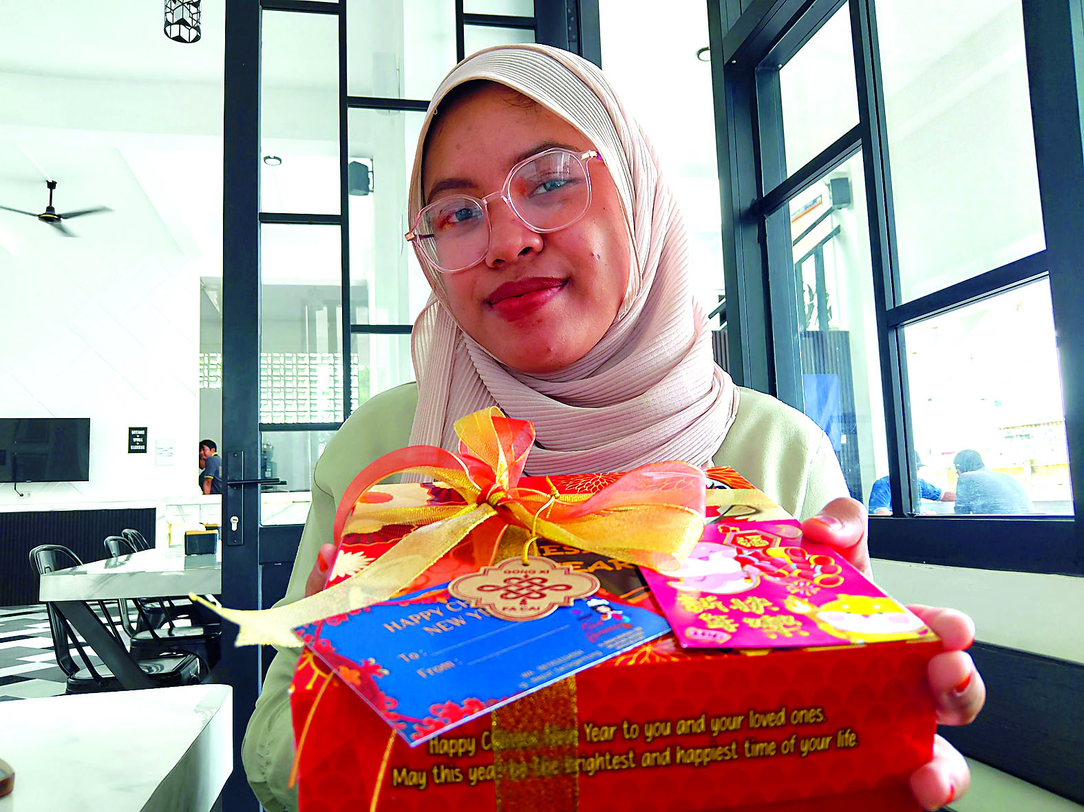 GURIH: Seorang pengunjung menunjukkan packaging hamper Imlek varian satu ekor ayam milik Gracia.