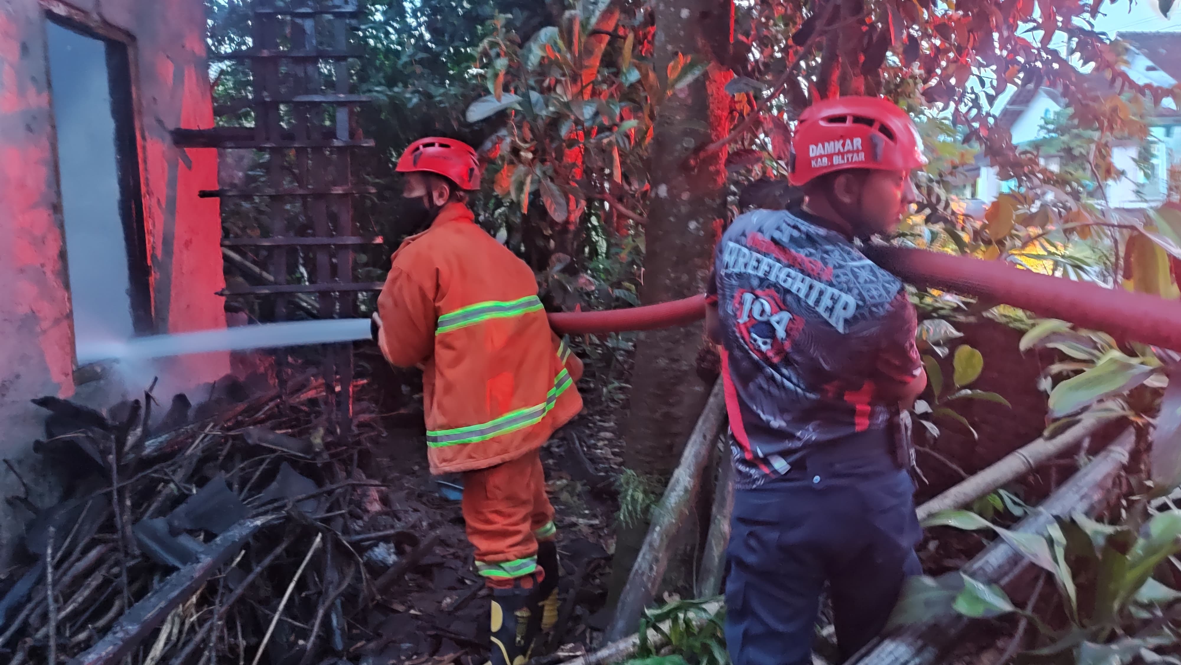 BERJUANG: Petugas pemadam kebakaran Kabupaten Blitar berjibaku memadamkan api yang membakar sebuah rumah beberapa waktu lalu.