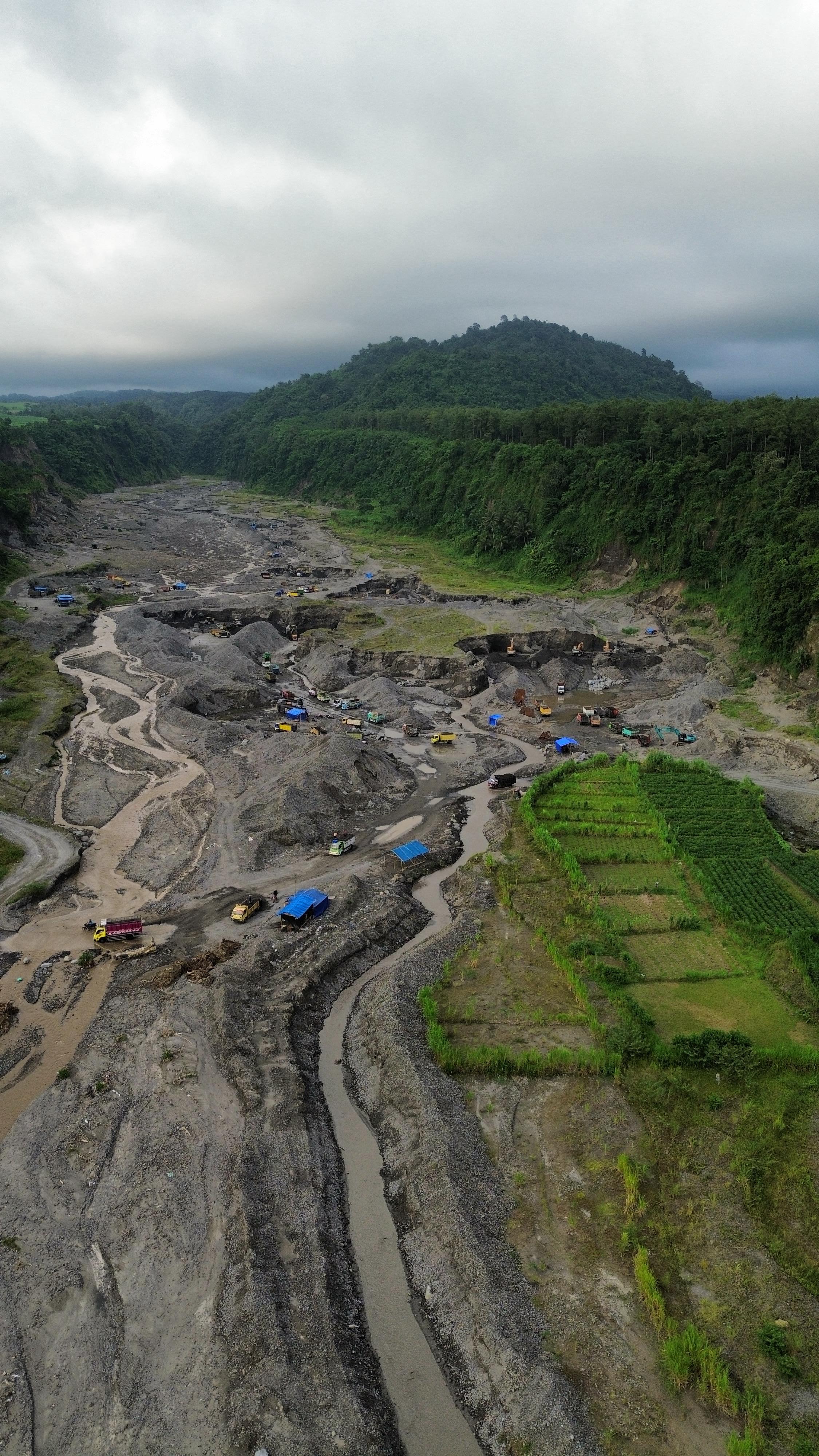 Aktivitas pertambangan di Kali Putih pada 5 Januari 2025, nampak Gunung Gedang, serta Gunung Kelud yang tertutup awan mendung.