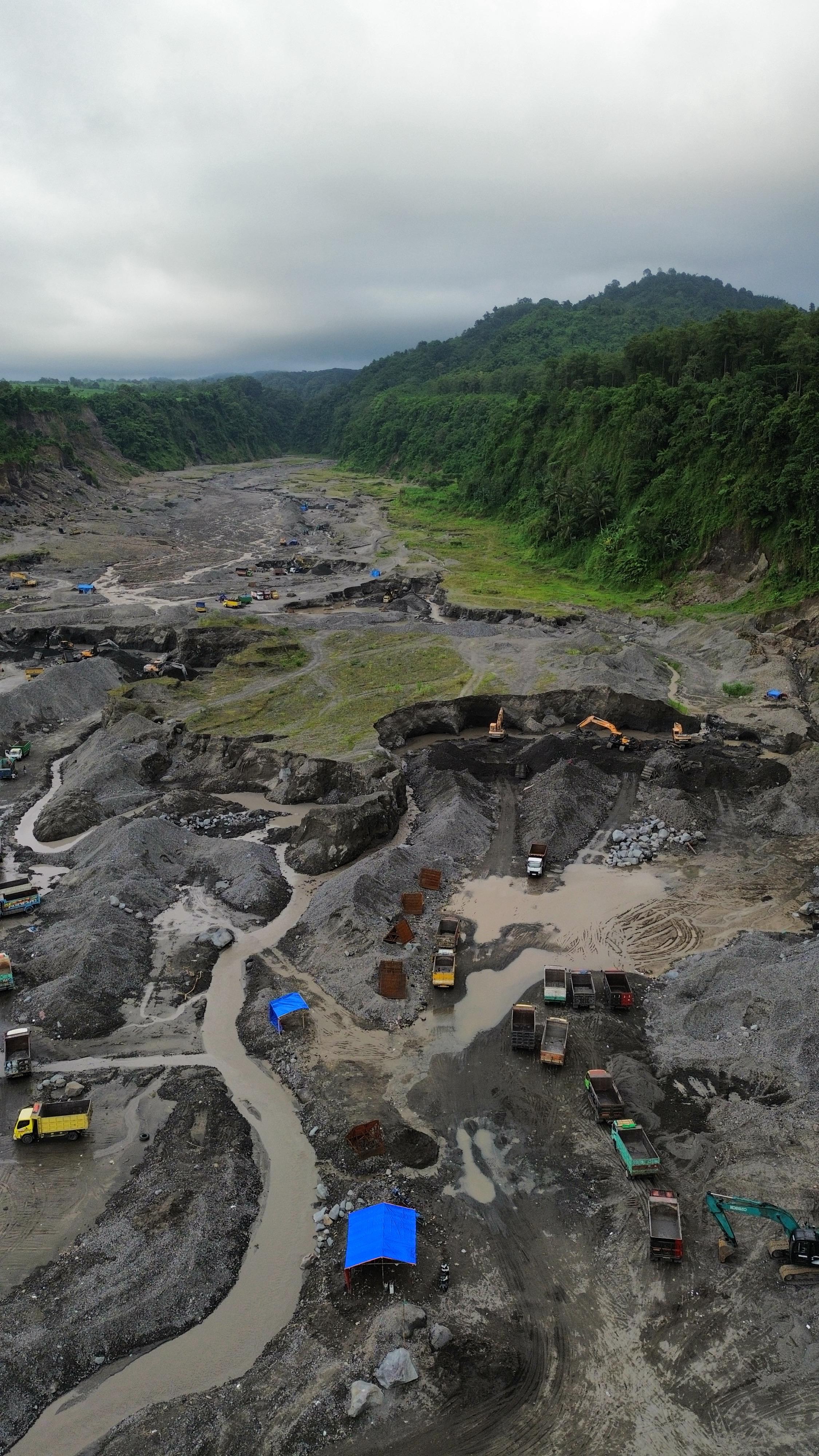 EKSPLOITASI: Aktivitas pertambangan di Kali Putih pada 5 Januari 2025, nampak Gunung Gedang, serta Gunung Kelud yang tertutup awan mendung.