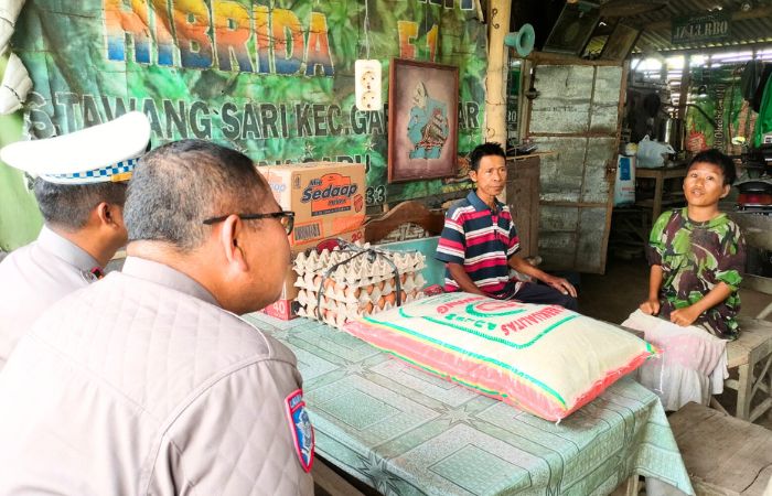 Kastlantas Polres Blitar AKP Alimuddin Nasution mendengarkan cerita dari putri korban laka dengan seksama.