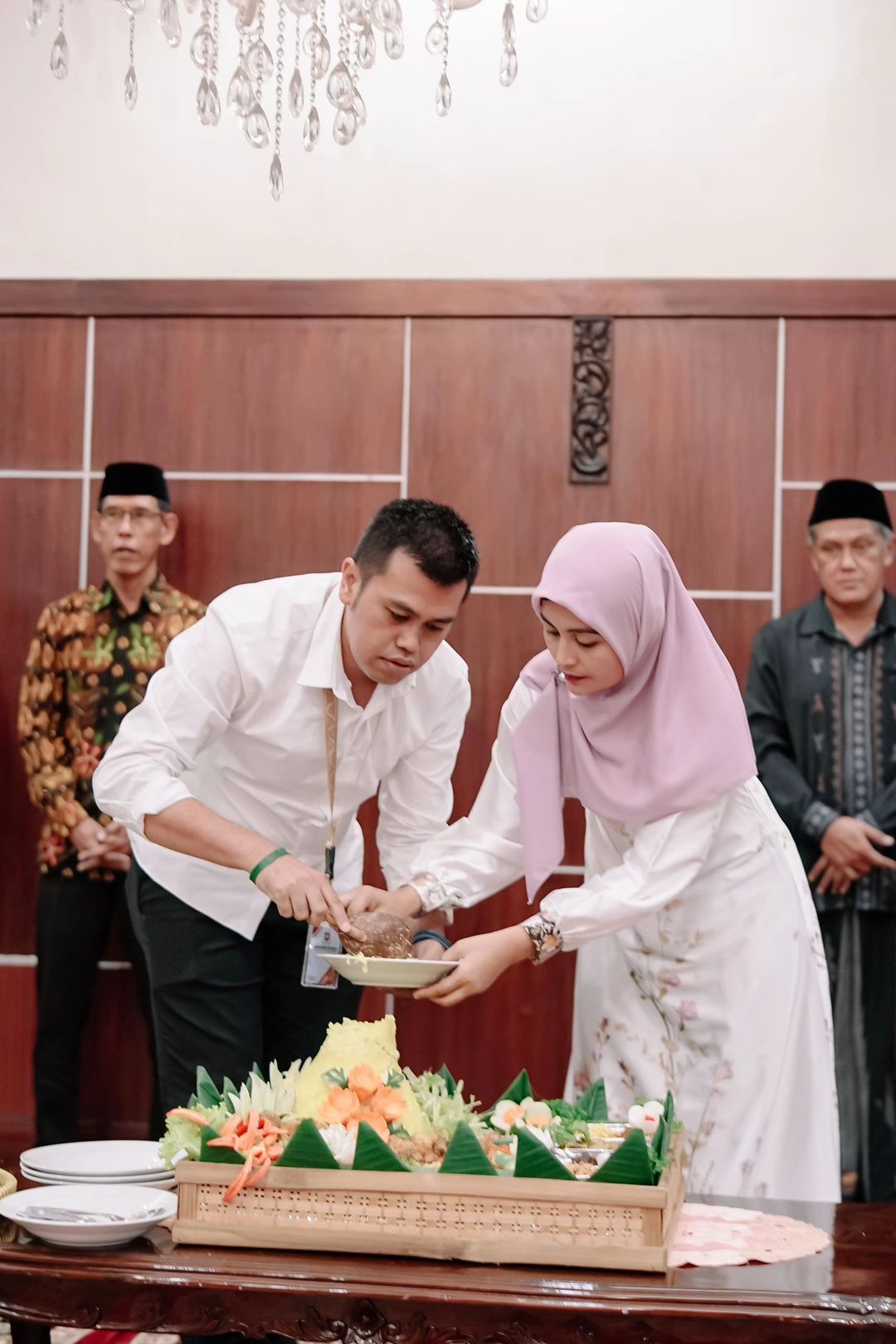 SYUKURAN: Mas Wali Kota Blitar, Syauqul Muhibbin memotong tumpeng dengan di dampingi istrinya dalam acara boyongan ke rumah dinas, Jumat (28/2/2025).