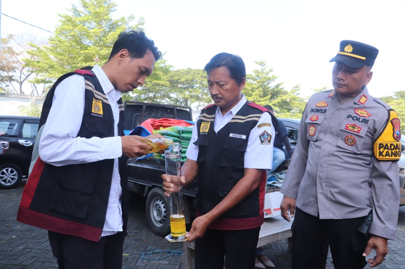 TERUKUR: Petugas uji tera melakukan pengecekan takaran pada MinyaKita kemasan plastik yang dijual di kegiatan operasi pasar, pada Rabu (12/3/2025).