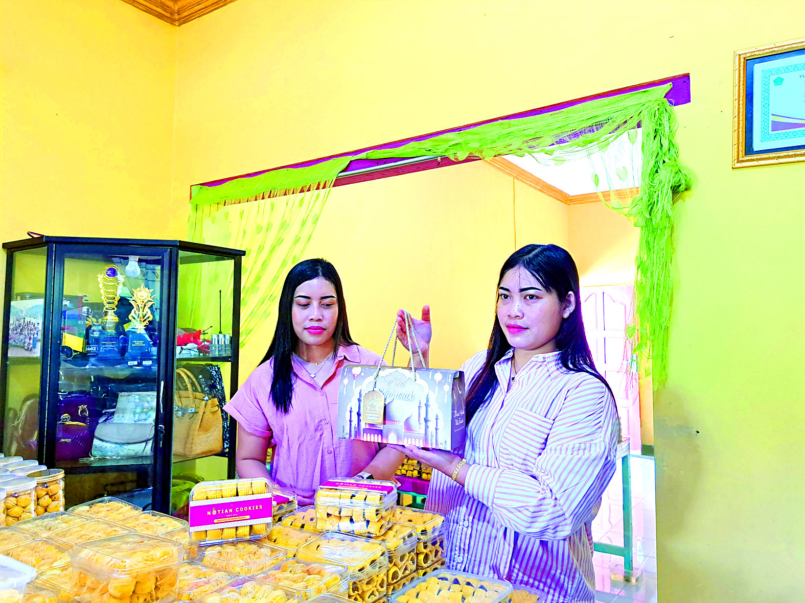 BACA PELUANG: Ria Notiansari dan Wahyu Rita Notiansari, warga Desa Sumberjati, Kecamatan Kademangan, Kabupaten Blitar dengan kue hasil produksi mereka.