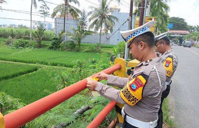 KBO Satlantas Polres Blitar, IPDA Mohammad Fahmi Yuliastato, bersama Kanit Kamsel, Aiptu Sutrisno memasang rambu reflektif (mata kucing) di beberapa jembatan di Kabupaten Blitar, Jumat (14/3/2025).