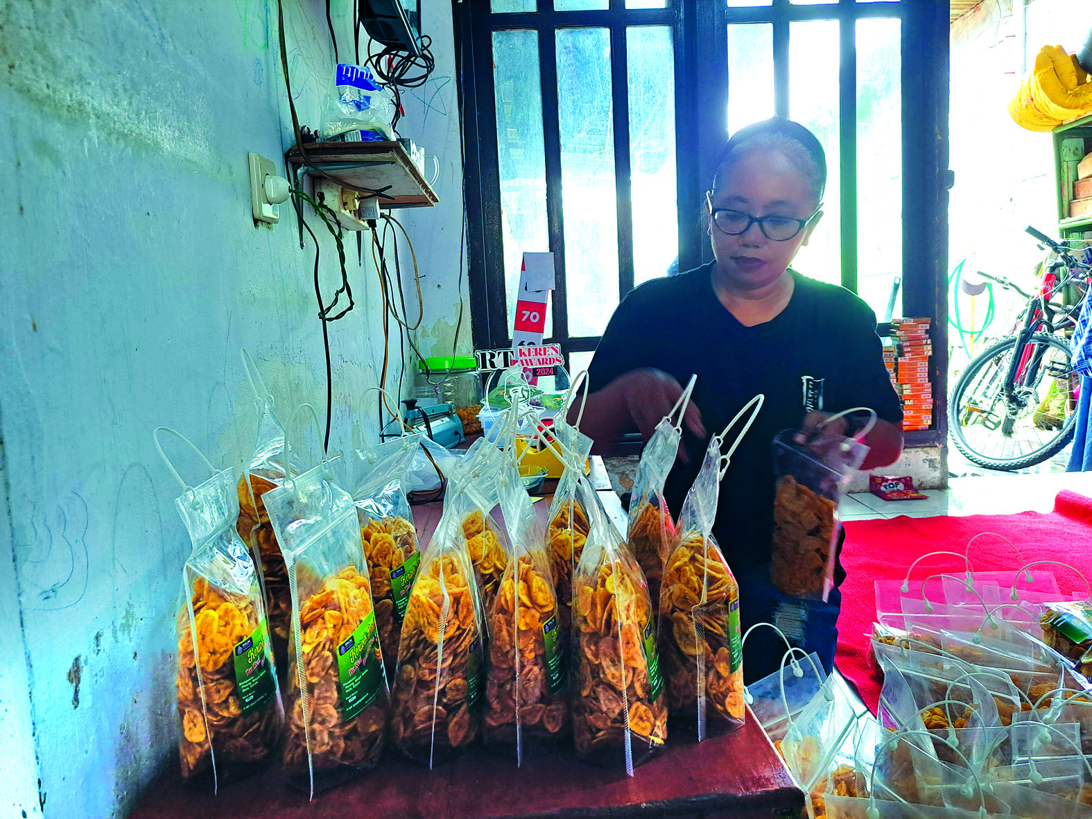 RAPI: Reni Setyawarni, warga Kelurahan Turi, Kecamatan Sukorejo, sedang menata keripik pisang buatannya, Rabu (19/3/2025).
