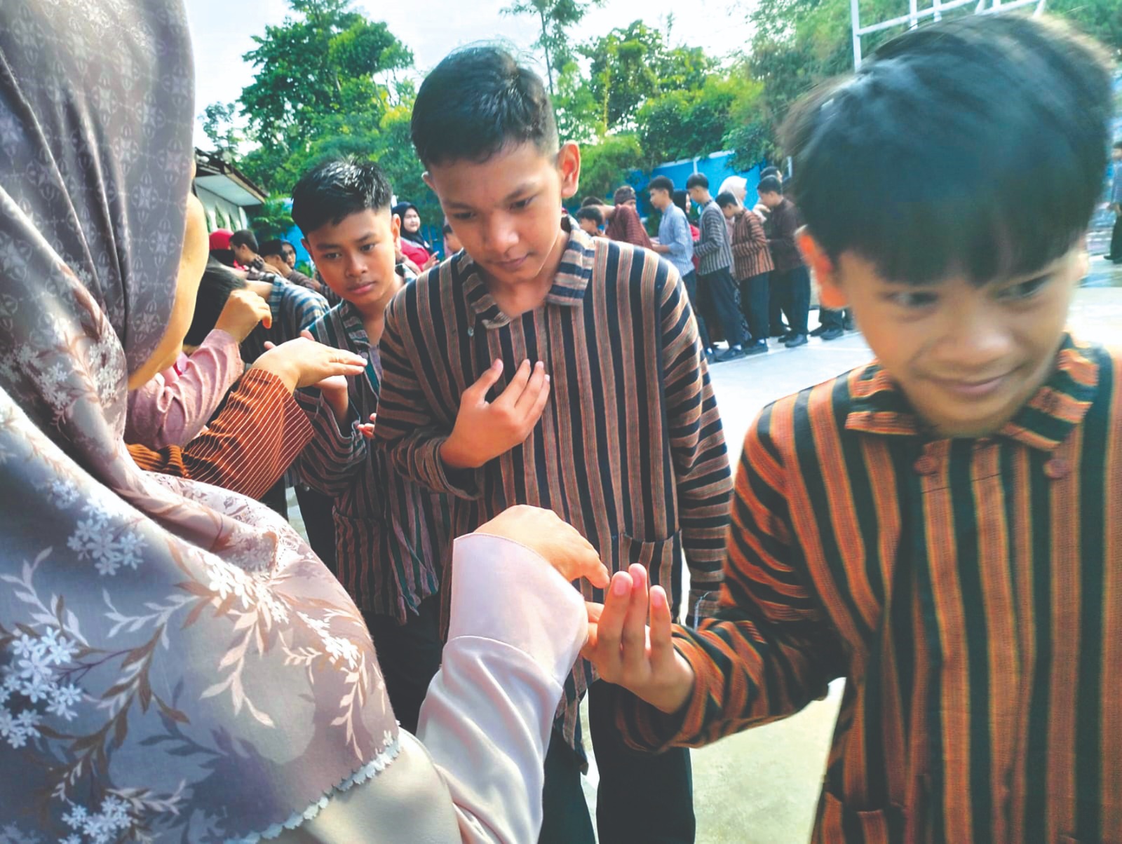 TRADISI TAHUNAN: Para siswa di SMPN 5 Blitar bersalaman dengan guru dan staf sekolah.
