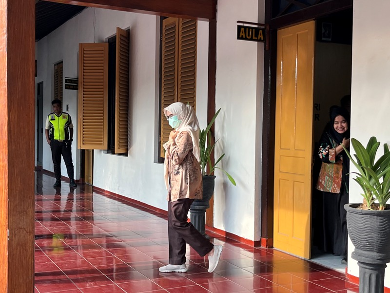 TAAT HUKUM: Mantan Bupati Blitar, Mak Rini melangkah keluar dari ruang pemeriksaan Kejari Kabupaten Blitar, Rabu (16/4/2025).