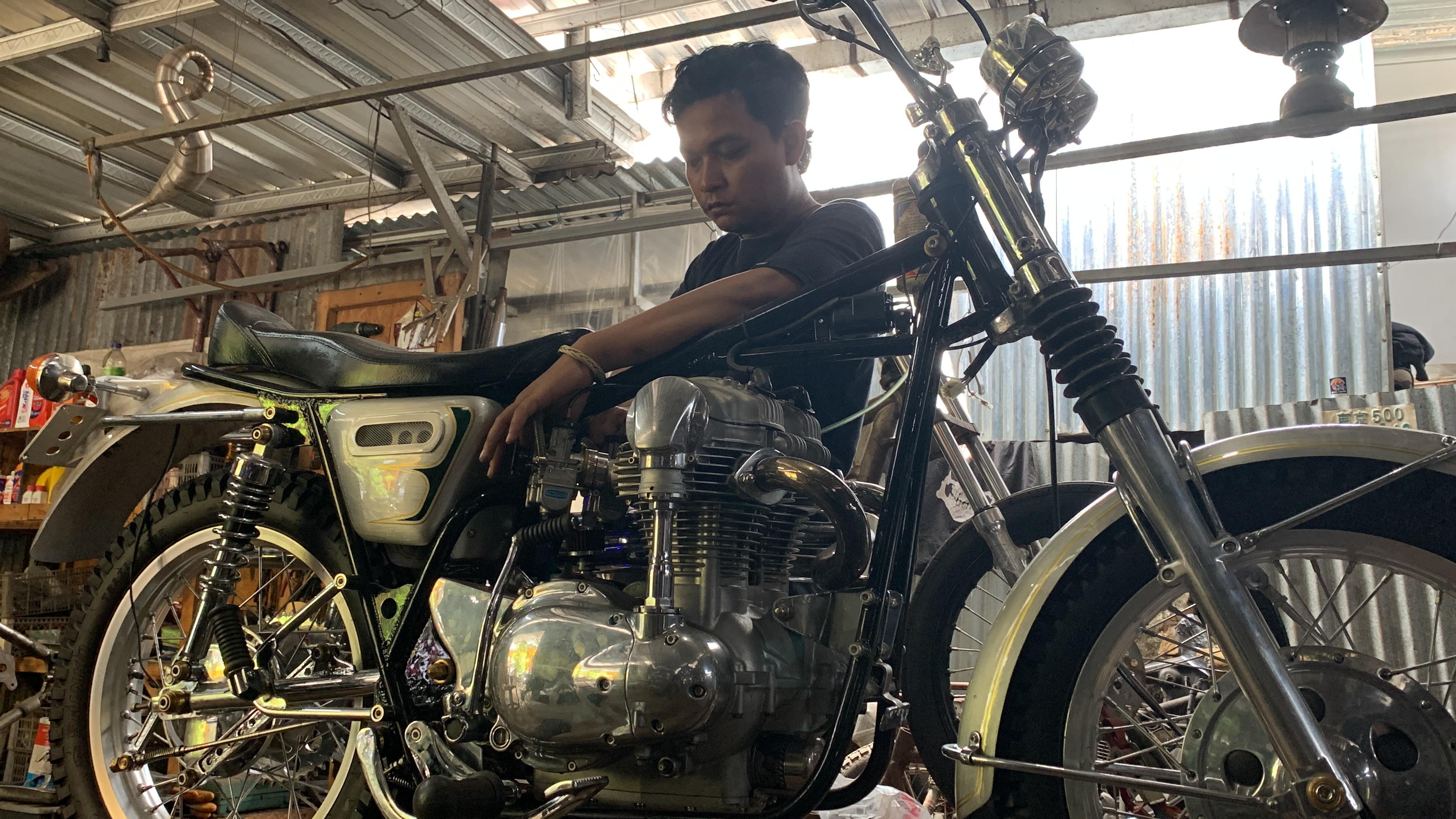 PEKERJA KERAS: Bagus Dwi Setiawan mencoba menyalakan mesin salah satu motor klasik hasil rakitan di bengkel miliknya beberapa waktu lalu.